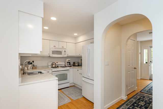 a view of a kitchen with refrigerator and cabinets