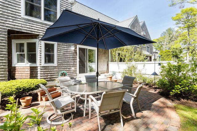 a view of patio with table and chairs under an umbrella