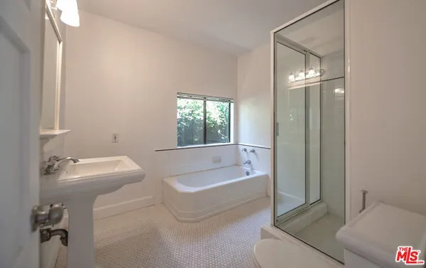 a bathroom with a tub a sink and a mirror