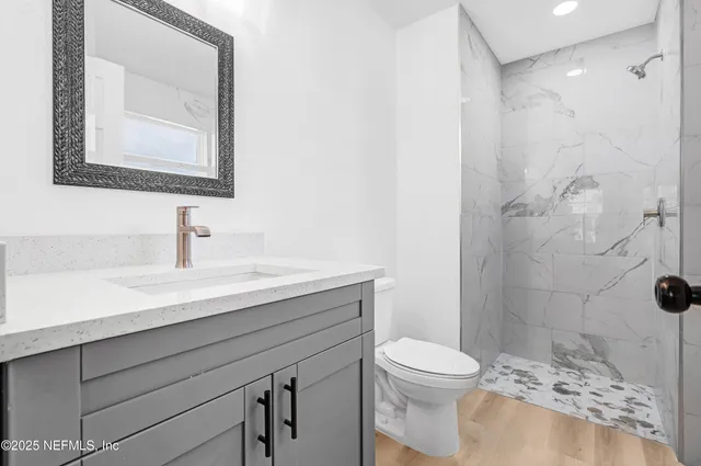 a bathroom with a sink a toilet and shower