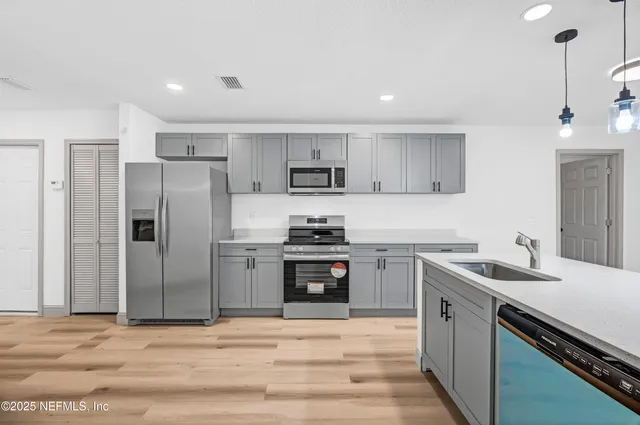 a kitchen with stainless steel appliances granite countertop a sink stove and refrigerator