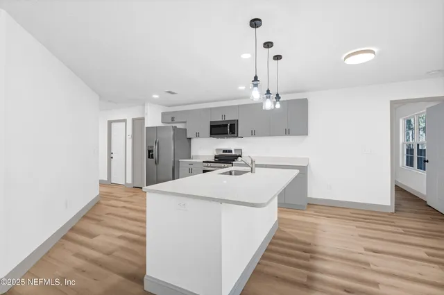 a kitchen with stainless steel appliances a refrigerator sink and microwave