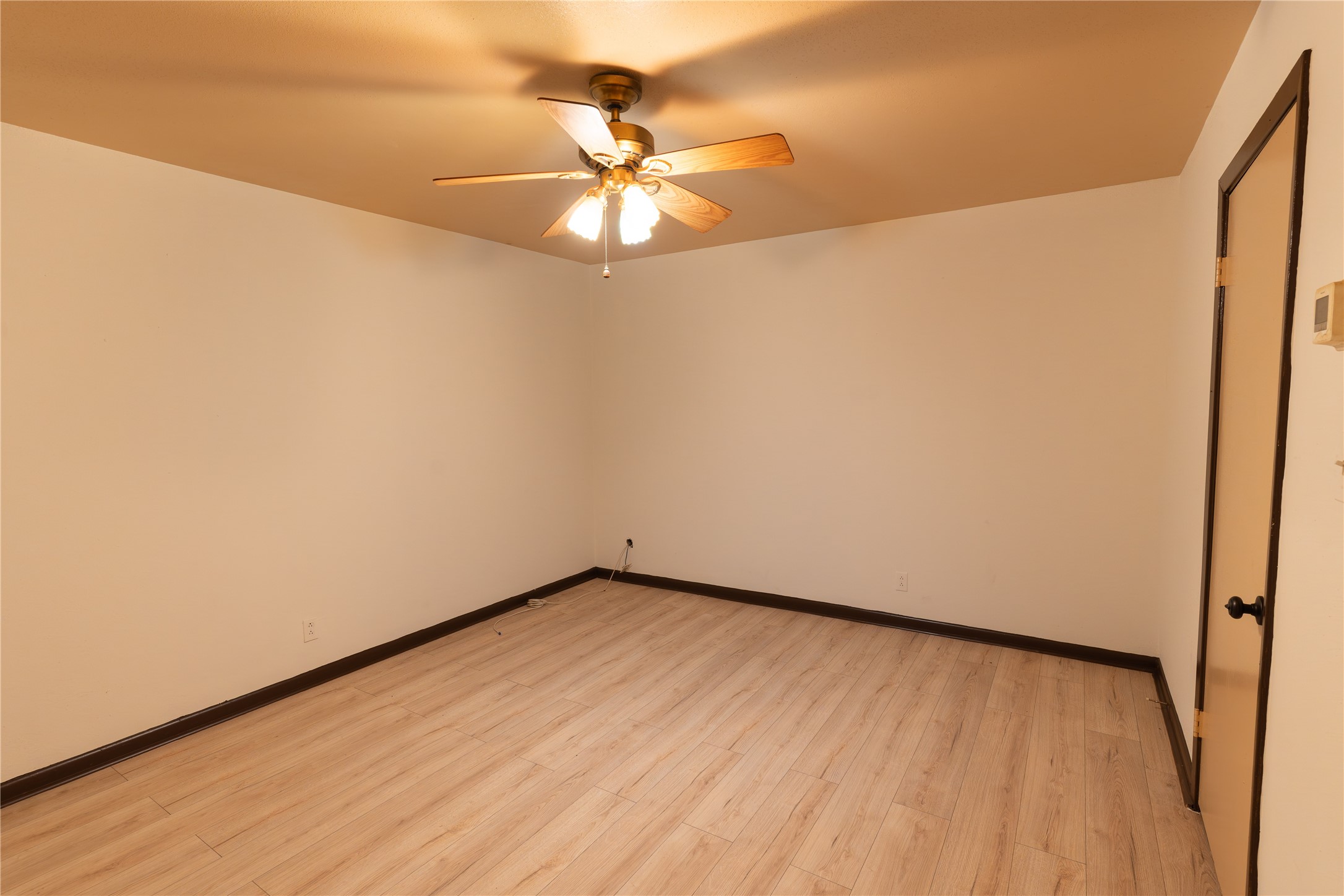 3314 Burke Road, Unit 39 Pasadena, TX 77504 - Photo 5 of 11 an empty room with a ceiling fan and wooden floor