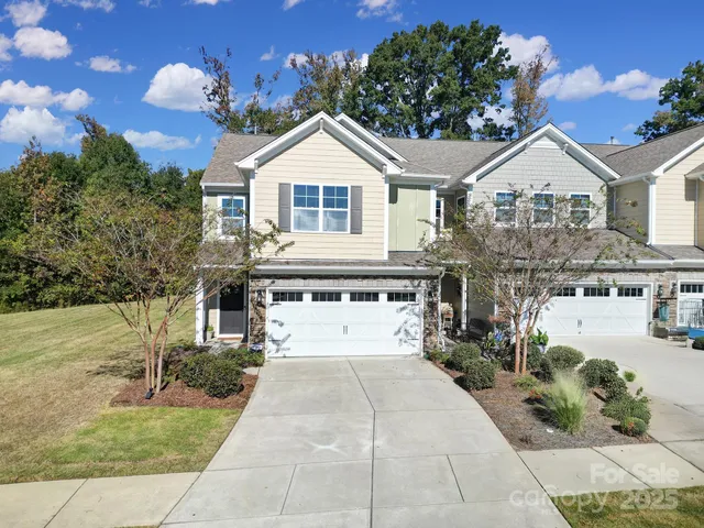a view of a white house with a yard and potted plants