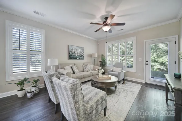 a living room with furniture and two large window
