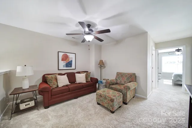 a living room with furniture and a ceiling fan