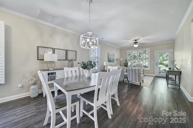a view of a dining room and livingroom with furniture wooden floor a chandelier