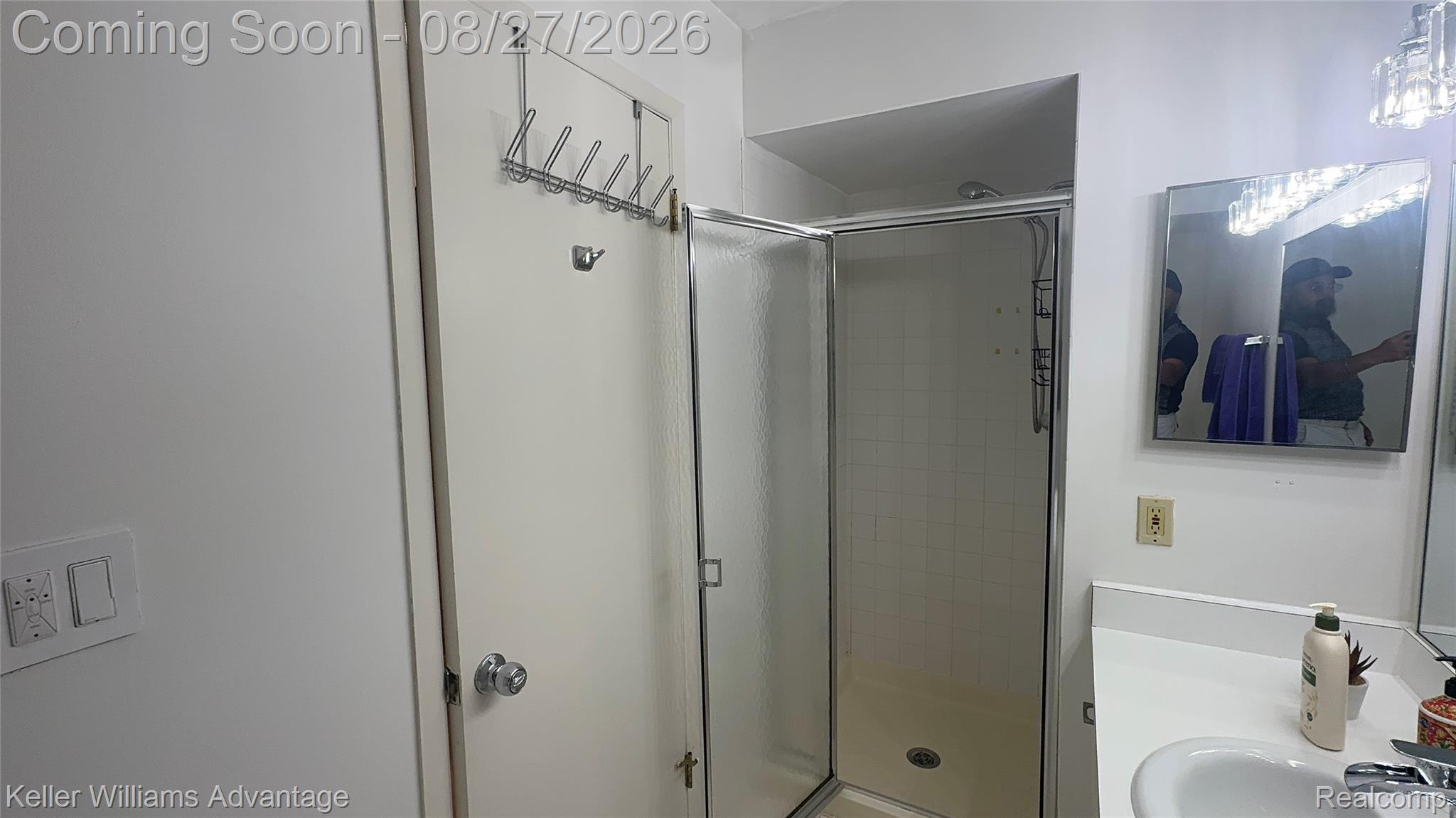 29726 Pine Ridge Circle Farmington, MI 48331 - Photo 37 of 42 Shower enclosure with glass door, tiled shower walls, single vanity with a white countertop, and wall-mounted medicine cabinet