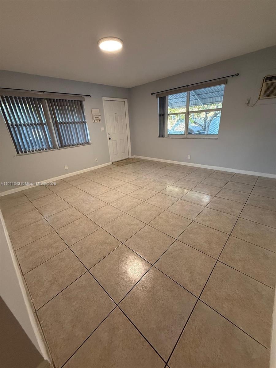 620 Southwest 7th Avenue, Unit 2 Hallandale Beach, FL 33009 - Photo 5 of 23 an empty room with windows and fireplace