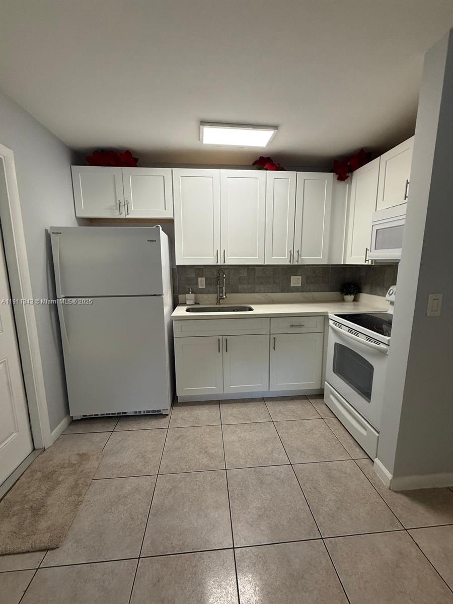 620 Southwest 7th Avenue, Unit 2 Hallandale Beach, FL 33009 - Photo 6 of 23 a kitchen with a cabinets and a refrigerator