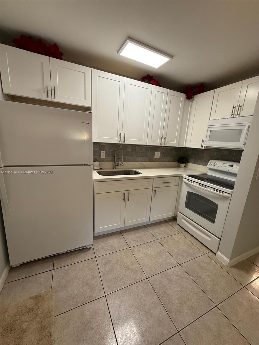 620 Southwest 7th Avenue, Unit 2 Hallandale Beach, FL 33009 - Photo 7 of 23 a kitchen with cabinets and white stainless steel appliances