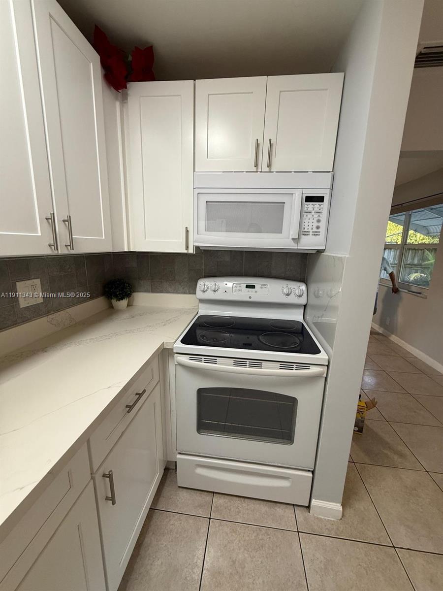 620 Southwest 7th Avenue, Unit 2 Hallandale Beach, FL 33009 - Photo 9 of 23 a kitchen with white cabinets and white appliances
