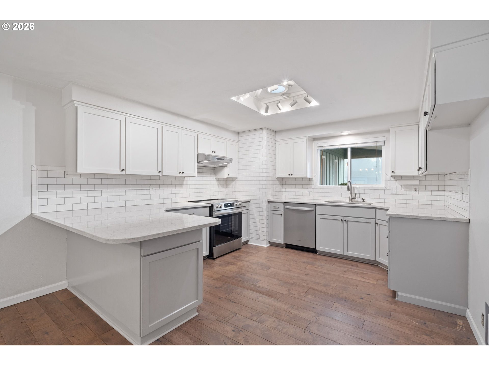 5546 Sinclair Street West Linn, OR 97068 - Photo 12 of 46 a kitchen with a white cabinets stove and kitchen island