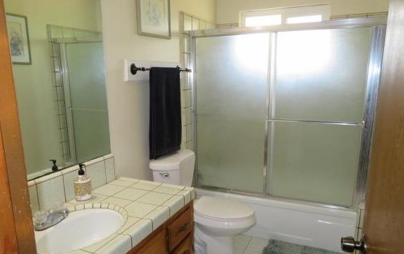 26681 Club Drive Madera, CA 93638 - Photo 22 of 41 a bathroom with a granite countertop sink toilet and shower