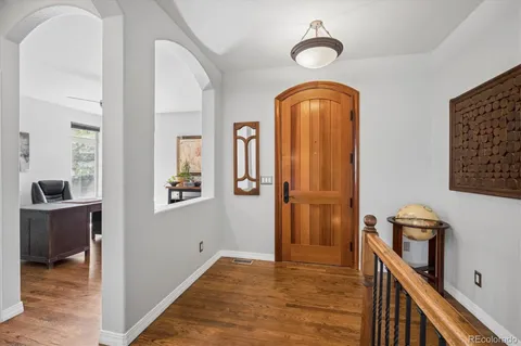 a view of front door with hallway and a chandelier