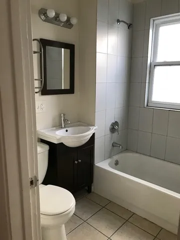 a bathroom with a sink toilet vanity and bathtub