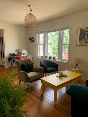 a living room with furniture a chandelier and a table