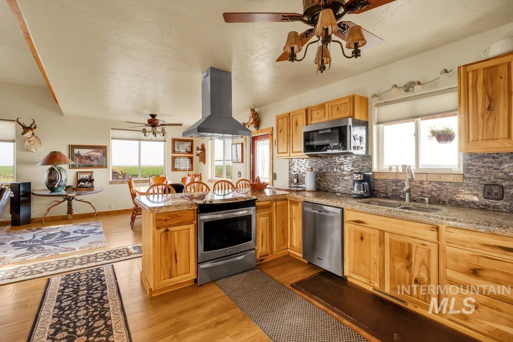 2530 4000 North Filer, ID 83328 - Photo 14 of 48 Kitchen with ceiling fan, island range hood, light wood-type flooring, and plenty of natural light