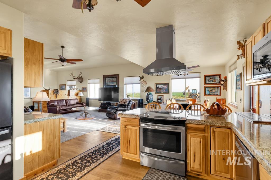 2530 4000 North Filer, ID 83328 - Photo 15 of 48 Kitchen with light stone counters, stainless steel appliances, island range hood, and light wood-type flooring
