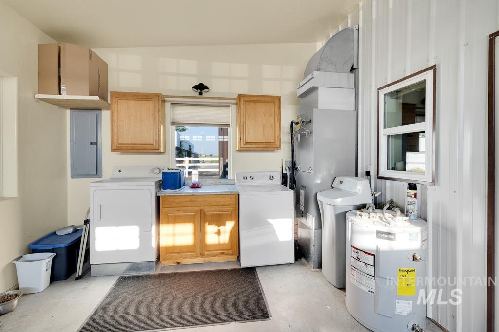 2530 4000 North Filer, ID 83328 - Photo 23 of 48 Laundry area with washer and dryer, cabinet space, electric water heater, electric panel, and heating unit