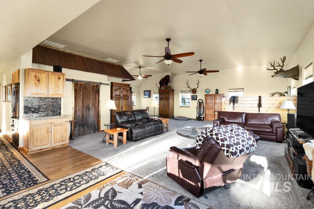 2530 4000 North Filer, ID 83328 - Photo 9 of 48 Living area featuring a barn door, vaulted ceiling, and light wood-style flooring