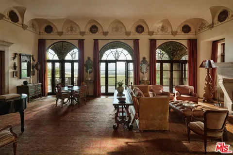 a living room with couches and dining area with wooden floor