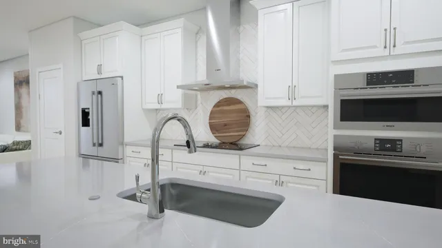a kitchen with granite countertop white cabinets and stainless steel appliances