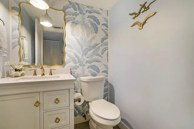 a bathroom with a granite countertop toilet sink and mirror