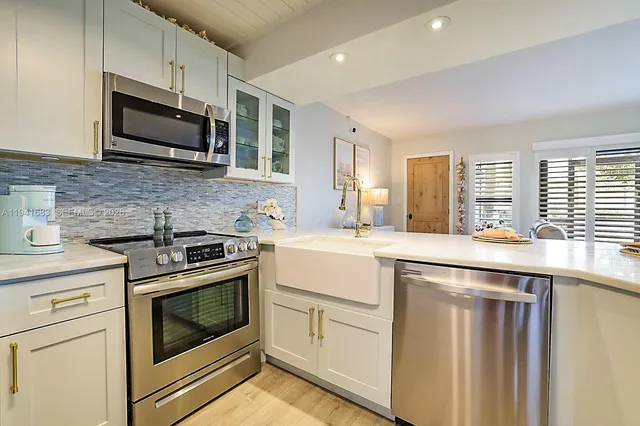 a kitchen with granite countertop cabinets stainless steel appliances and sink