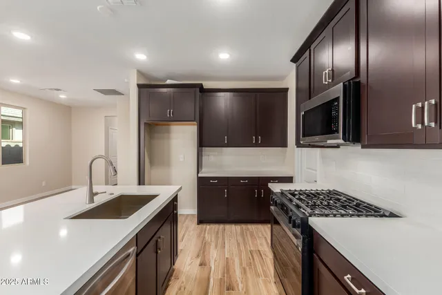 a kitchen with granite countertop a sink stove and refrigerator