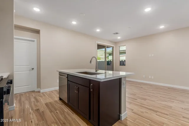 a kitchen with a stove and wooden floor