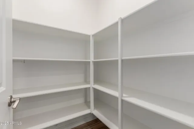 a view of walk in closet with empty racks