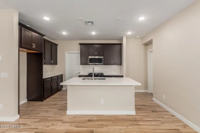 a view of a kitchen with stainless steel appliances granite countertop a stove top oven a sink and a refrigerator