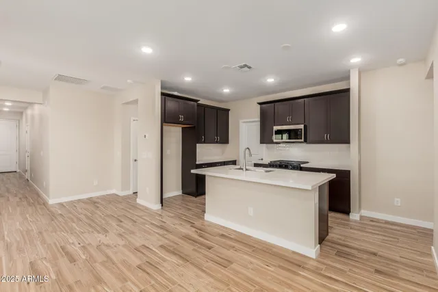 a kitchen with stainless steel appliances granite countertop a refrigerator stove top oven and sink