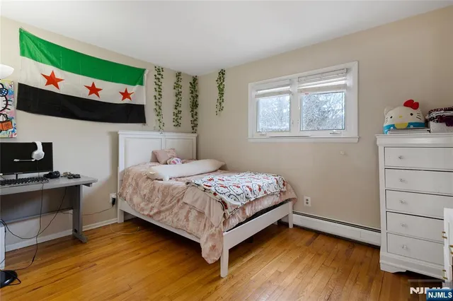 a bedroom with a bed wooden floor and window
