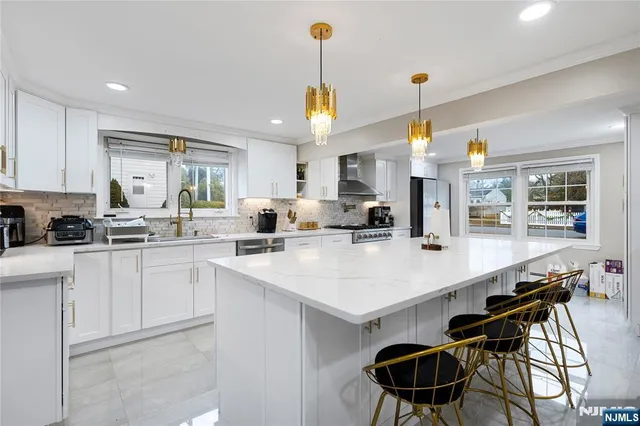 a kitchen with a dining table chairs sink and cabinets