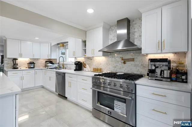 a kitchen with granite countertop stainless steel appliances and white cabinets