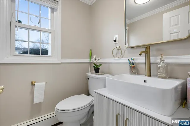 a bathroom with a sink a toilet and a mirror