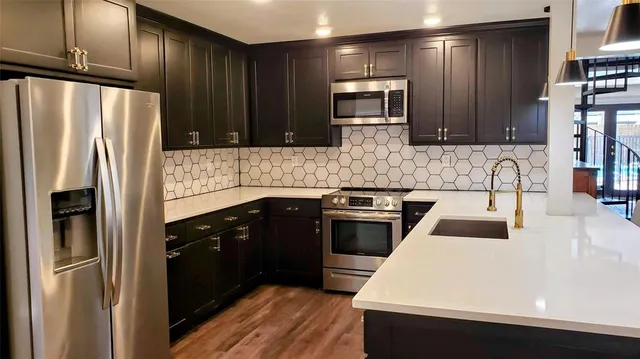 a kitchen with a sink and stainless steel appliances