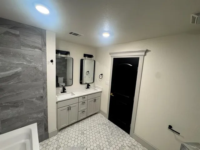 a bathroom with a double vanity sink and mirror
