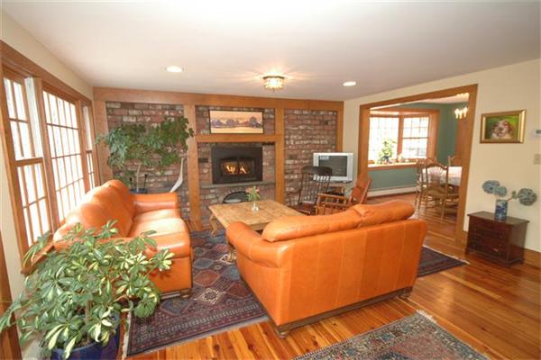 76 Holt Road Andover, MA 01810 - Photo 6 of 30 a living room with furniture a fireplace and a floor to ceiling window