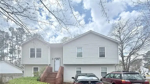 a front view of a house with cars parked
