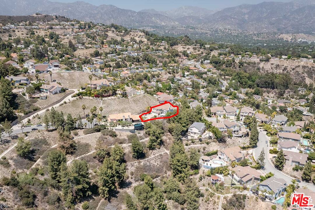an aerial view of house with yard and mountain in the background