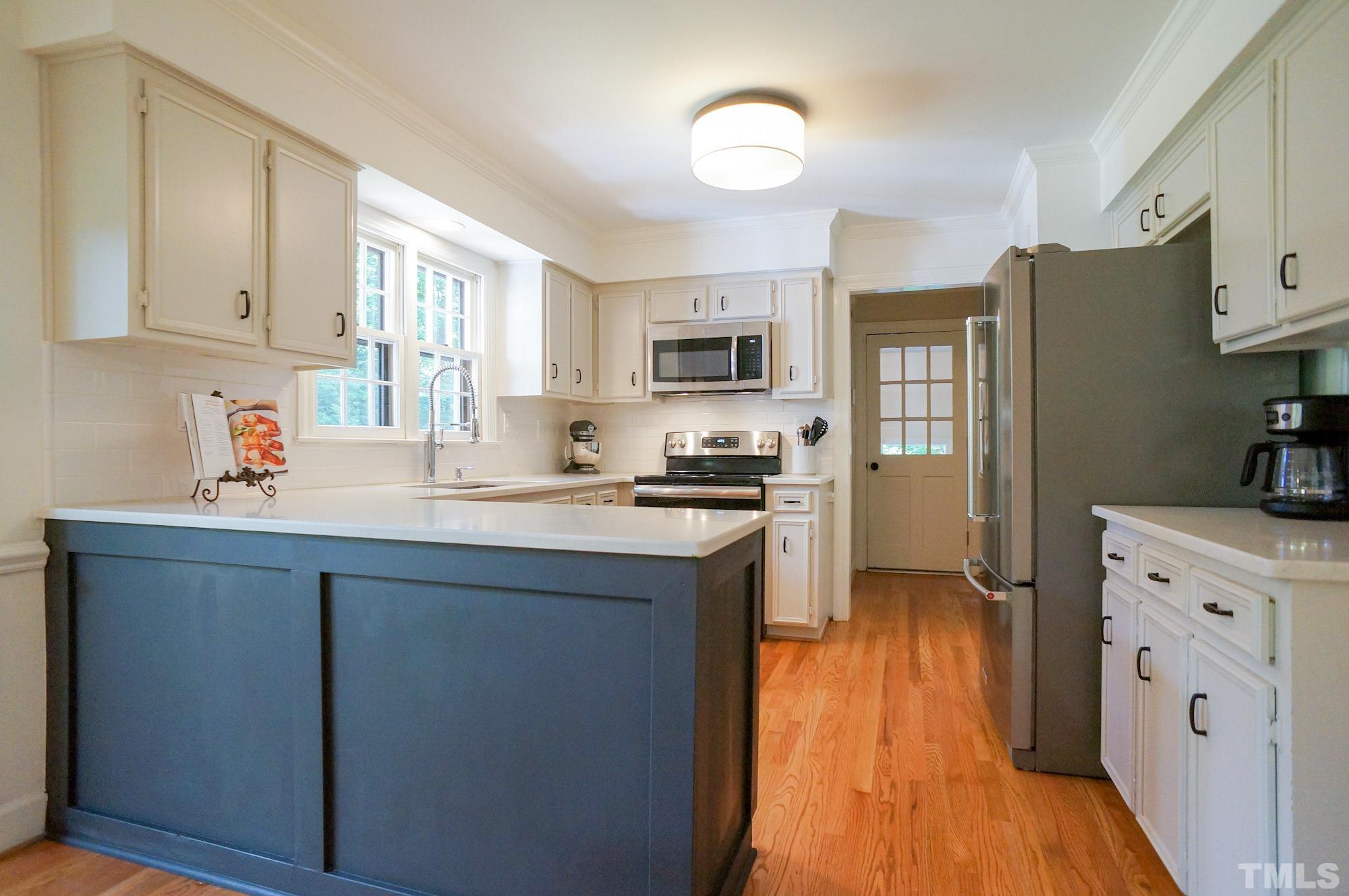 408 Emerywood Drive Raleigh, NC 27615 - Photo 11 of 44 a kitchen with cabinets wooden floor and a window