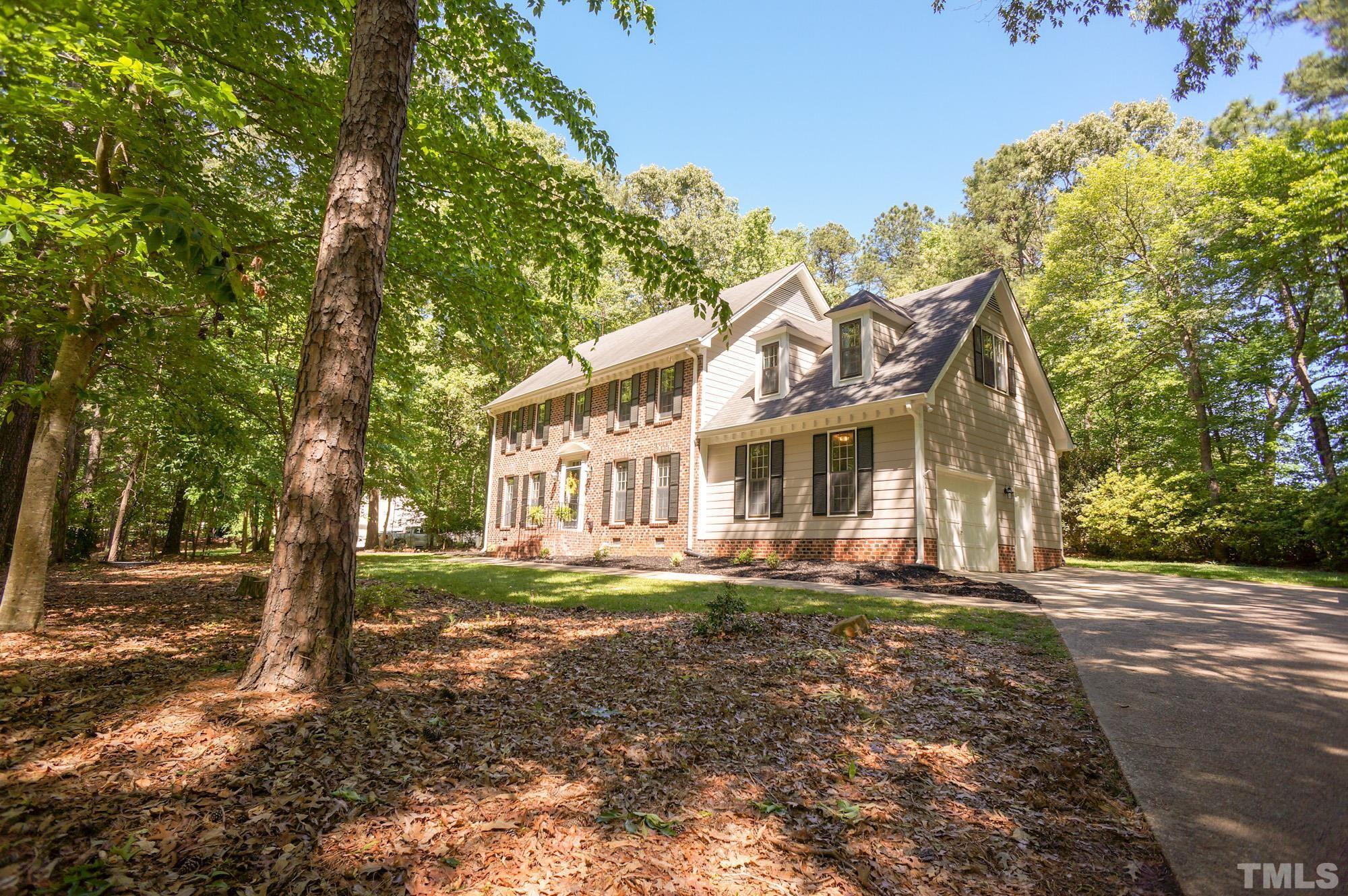 408 Emerywood Drive Raleigh, NC 27615 - Photo 42 of 44 a view of a big house with large trees and a small yard
