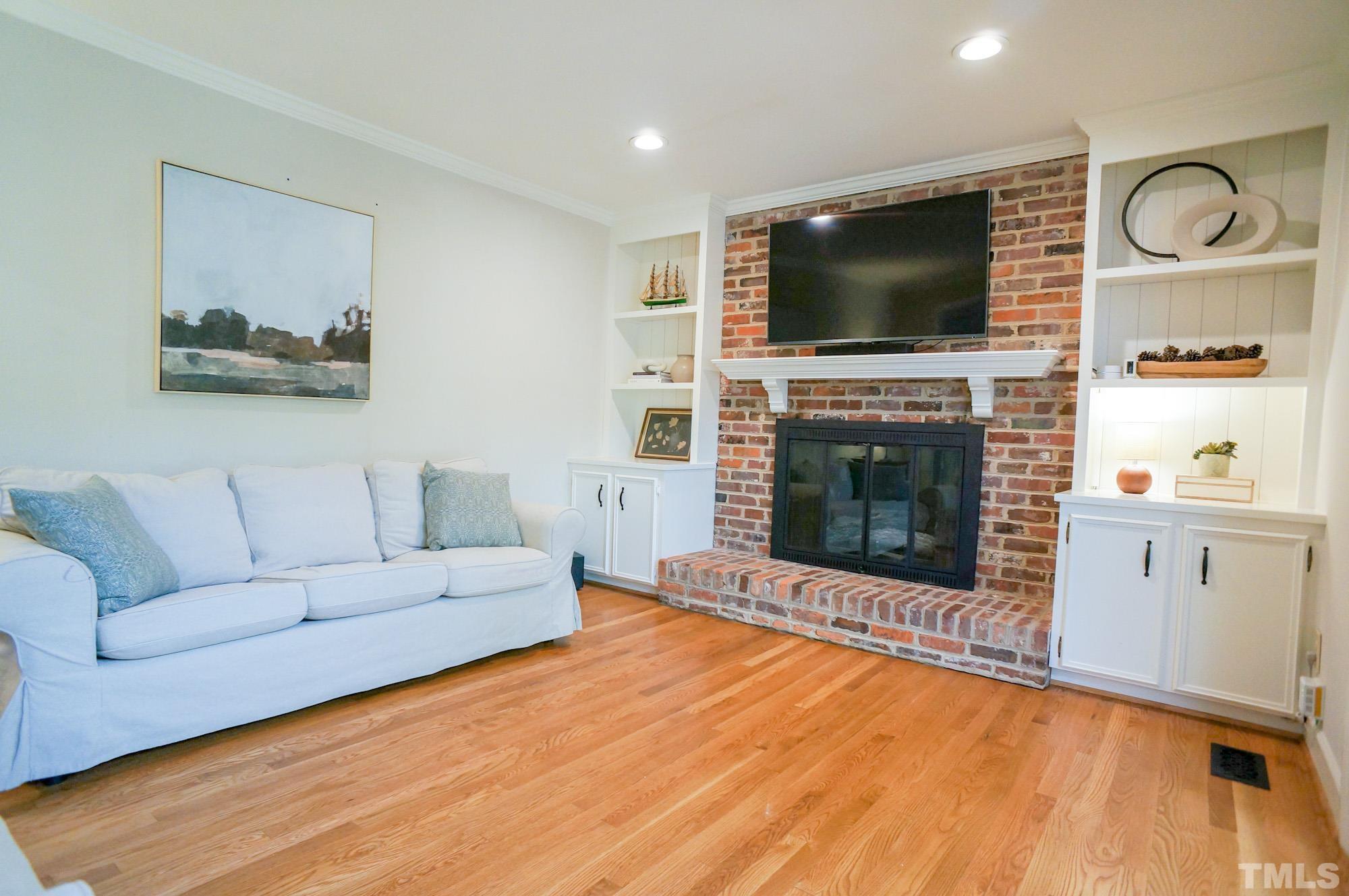 408 Emerywood Drive Raleigh, NC 27615 - Photo 6 of 44 a living room with furniture a flat screen tv and a fireplace
