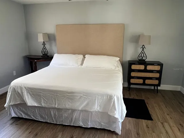 a bedroom with a bed and wooden floor