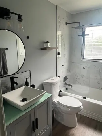 a bathroom with a sink mirror toilet and bathtub