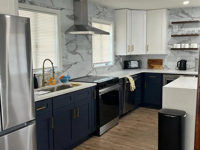 a kitchen with stainless steel appliances granite countertop a sink stove and refrigerator