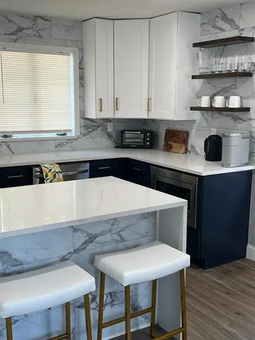 a kitchen with appliances cabinets and wooden floor